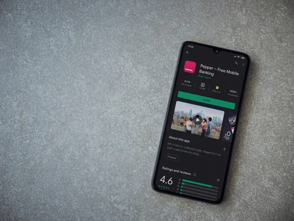 Lod, Israel - 8 Temmuz 2020: Biber uygulaması oyun mağazası sayfası seramik taş zemin üzerinde siyah bir cep telefonu görüntüsü. Üst görünüm düzlüğü kopyalama alanı ile yatıyordu.