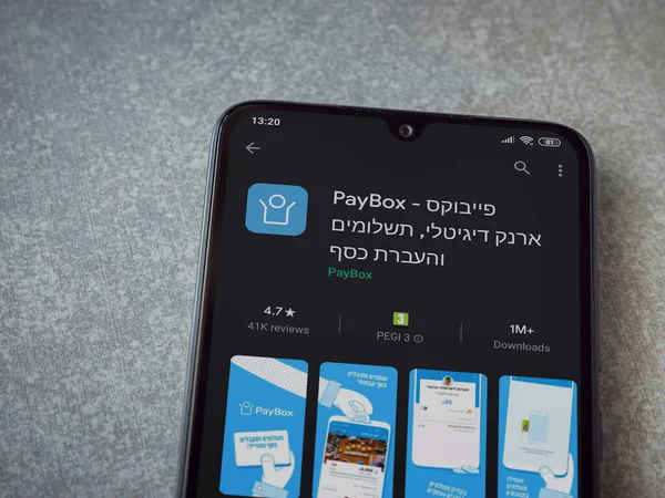 Lod, Israel - 8 Temmuz 2020: PayBox uygulaması oyun mağazası sayfası seramik taş zemin üzerinde siyah bir cep telefonu görüntüsü. Üst görünüm düzlüğü kopyalama alanı ile yatıyordu.