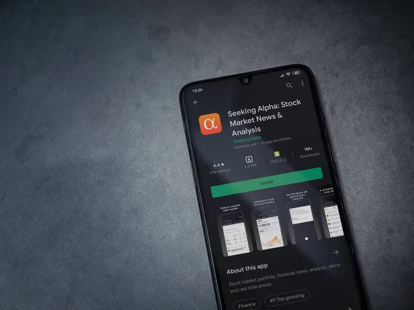 Lod, Israel - 8 Temmuz 2020: Koyu mermer taşlı arka planda siyah bir cep telefonunun ekranında Alfa uygulaması oyun mağazası sayfası aranıyor. Üst görünüm düzlüğü kopyalama alanı ile yatıyordu.