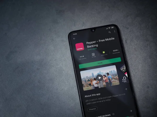 Lod, Israel - 8 Temmuz 2020: Koyu mermer taştan arka planda siyah bir cep telefonunun sergilendiği biber uygulaması oyun mağazası sayfası. Üst görünüm düzlüğü kopyalama alanı ile yatıyordu.