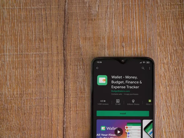 Lod, Israel - 8 Temmuz 2020: Cüzdan uygulaması oyun mağazası sayfası ahşap arka planda siyah bir cep telefonu ekranında. Üst görünüm düzlüğü kopyalama alanı ile yatıyordu.