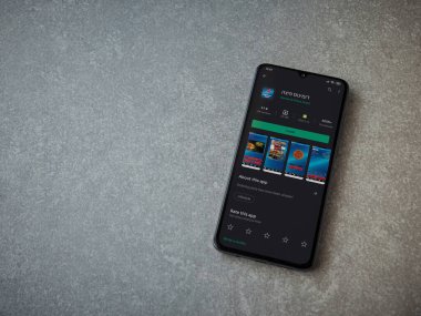 Lod, Israel - 8 Temmuz 2020: Domino 'nun Pizza Israel uygulaması oyun mağazası sayfası seramik taş zemin üzerinde siyah bir cep telefonunun görüntüsü. Üst görünüm düzlüğü kopyalama alanı ile yatıyordu.