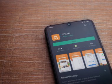 Lod, Israel - 8 Temmuz 2020: 10bis uygulama oyun mağazası sayfası ahşap arka planda siyah bir cep telefonu ekranında. Üst görünüm düzlüğü kopyalama alanı ile yatıyordu.