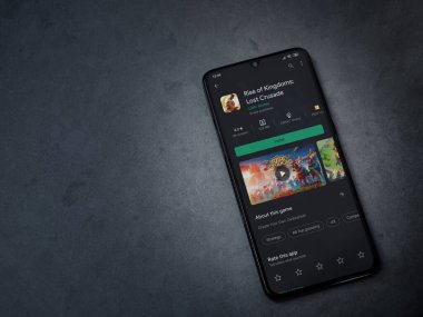 Lod, Israel - 8 Temmuz 2020: Rise of Kingdoms uygulamasının oyun mağazası sayfası koyu mermer taşlı arka planda siyah bir cep telefonunun ekranında. Üst görünüm düzlüğü kopyalama alanı ile yatıyordu.