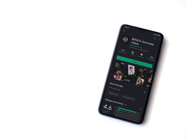Lod, Israel - 8 Temmuz 2020: Uygulama oyun mağazası sayfasını beyaz arkaplanda izole edilmiş siyah bir cep telefonunun ekranına yansıt. Üst görünüm düzlüğü kopyalama alanı ile yatıyordu.