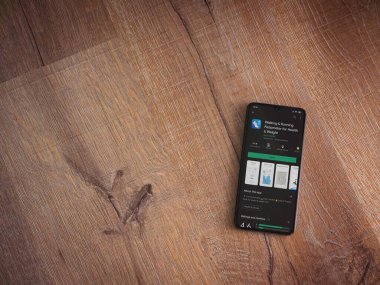 Lod, Israel - 8 Temmuz 2020: Yürüyen ve Koşan Pedometre uygulaması oyun mağazası sayfası ahşap arka planda siyah bir cep telefonu görüntüsü. Üst görünüm düzlüğü kopyalama alanı ile yatıyordu.