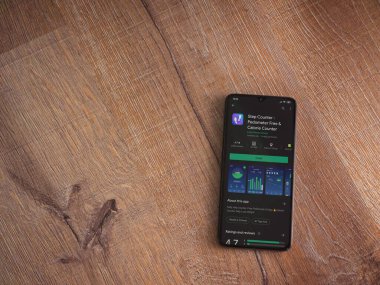 Lod, Israel - 8 Temmuz 2020: Step Counter uygulama oyun mağazası sayfası ahşap arka planda siyah bir cep telefonunun ekranında. Üst görünüm düzlüğü kopyalama alanı ile yatıyordu.