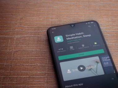 Lod, Israel - 8 Temmuz 2020: Basit Alışkanlık uygulaması oyun mağazası sayfası ahşap arka planda siyah bir cep telefonunun ekranında. Üst görünüm düzlüğü kopyalama alanı ile yatıyordu.