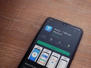 Lod, Israel - 8 Temmuz 2020: Ahşap arka planda siyah bir cep telefonunun ekranında yedi uygulama mağaza sayfası. Üst görünüm düzlüğü kopyalama alanı ile yatıyordu.