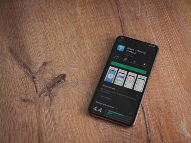 Lod, Israel - 8 Temmuz 2020: Ahşap arka planda siyah bir cep telefonunun ekranında yedi uygulama mağaza sayfası. Üst görünüm düzlüğü kopyalama alanı ile yatıyordu.