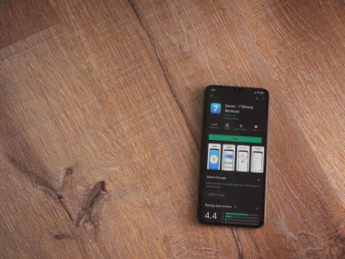 Lod, Israel - 8 Temmuz 2020: Ahşap arka planda siyah bir cep telefonunun ekranında yedi uygulama mağaza sayfası. Üst görünüm düzlüğü kopyalama alanı ile yatıyordu.