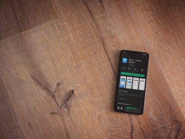 Lod, Israel - 8 Temmuz 2020: Ahşap arka planda siyah bir cep telefonunun ekranında yedi uygulama mağaza sayfası. Üst görünüm düzlüğü kopyalama alanı ile yatıyordu.