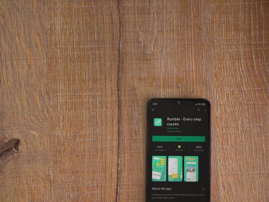 Lod, Israel - 8 Temmuz 2020: Rumble uygulama oyun mağazası sayfası ahşap arka planda siyah bir cep telefonunun ekranında. Üst görünüm düzlüğü kopyalama alanı ile yatıyordu.