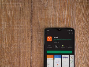 Lod, Israel - 8 Temmuz 2020: Mi Fit uygulaması oyun mağazası sayfası ahşap arka planda siyah bir cep telefonunun ekranında. Üst görünüm düzlüğü kopyalama alanı ile yatıyordu.