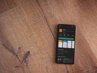 Lod, Israel - 8 Temmuz 2020: Mi Fit uygulaması oyun mağazası sayfası ahşap arka planda siyah bir cep telefonunun ekranında. Üst görünüm düzlüğü kopyalama alanı ile yatıyordu.