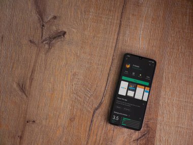 Lod, Israel - 8 Temmuz 2020: Meuhedet Sağlık Hizmetleri uygulama oyun mağazası sayfası ahşap arka planda siyah bir cep telefonu sergilenmektedir. Üst görünüm düzlüğü kopyalama alanı ile yatıyordu.