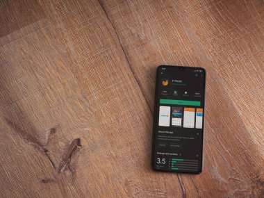 Lod, Israel - 8 Temmuz 2020: Meuhedet Sağlık Hizmetleri uygulama oyun mağazası sayfası ahşap arka planda siyah bir cep telefonu sergilenmektedir. Üst görünüm düzlüğü kopyalama alanı ile yatıyordu.