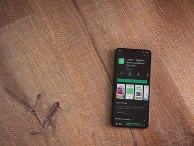 Lod, Israel - 8 Temmuz 2020: Lifesum uygulama oyun mağazası sayfası ahşap arka planda siyah bir cep telefonu ekranında. Üst görünüm düzlüğü kopyalama alanı ile yatıyordu.