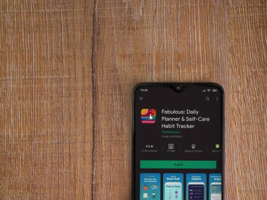 Lod, Israel - 8 Temmuz 2020: Ahşap arka planda siyah bir cep telefonunun sergilendiği harika bir uygulama oyun mağazası sayfası. Üst görünüm düzlüğü kopyalama alanı ile yatıyordu.