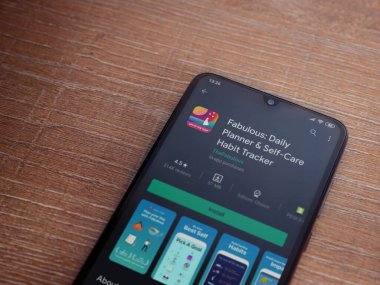 Lod, Israel - 8 Temmuz 2020: Ahşap arka planda siyah bir cep telefonunun sergilendiği harika bir uygulama oyun mağazası sayfası. Üst görünüm düzlüğü kopyalama alanı ile yatıyordu.