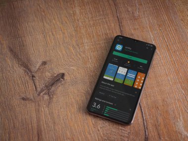 Lod, Israel - 8 Temmuz 2020: Clalit Sağlık Hizmetleri uygulama oyun mağazası sayfası ahşap arka planda siyah bir cep telefonu sergilenmektedir. Üst görünüm düzlüğü kopyalama alanı ile yatıyordu.