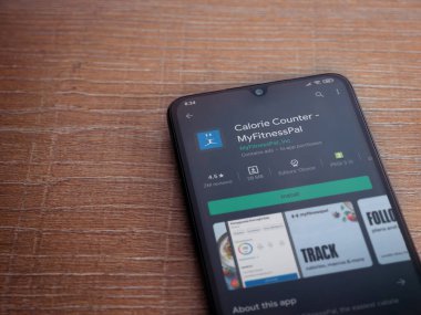 Lod, Israel - 8 Temmuz 2020: MyFitnessPal uygulama oyun mağazası sayfası ahşap arka planda siyah bir cep telefonunun ekranında. Üst görünüm düzlüğü kopyalama alanı ile yatıyordu.