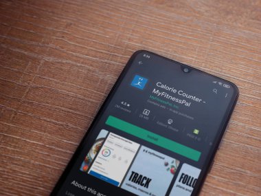 Lod, Israel - 8 Temmuz 2020: MyFitnessPal uygulama oyun mağazası sayfası ahşap arka planda siyah bir cep telefonunun ekranında. Üst görünüm düzlüğü kopyalama alanı ile yatıyordu.