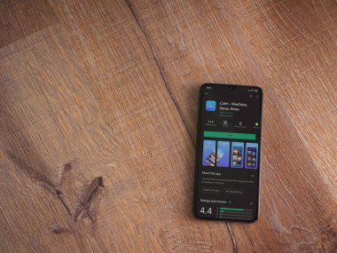 Lod, Israel - 8 Temmuz 2020: Ahşap arka planda siyah bir cep telefonunun sergilendiği sakin uygulama oyun mağazası sayfası. Üst görünüm düzlüğü kopyalama alanı ile yatıyordu.