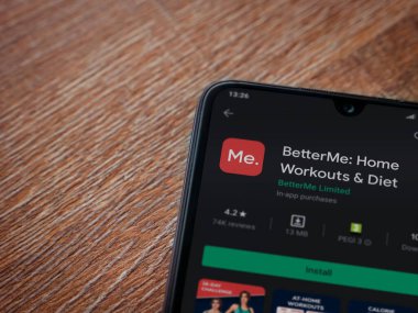 Lod, Israel - 8 Temmuz 2020: BetterMe uygulama oyun mağazası sayfası ahşap arka planda siyah bir cep telefonunun ekranında. Üst görünüm düzlüğü kopyalama alanı ile yatıyordu.