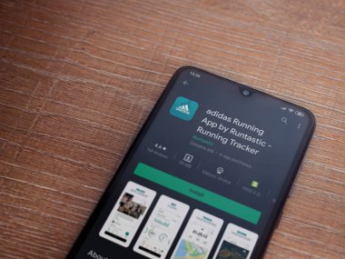 Lod, Israel - 8 Temmuz 2020: Adidas Running app playshop sayfası ahşap arka planda siyah bir cep telefonunun ekranında. Üst görünüm düzlüğü kopyalama alanı ile yatıyordu.