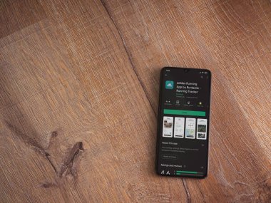 Lod, Israel - 8 Temmuz 2020: Adidas Running app playshop sayfası ahşap arka planda siyah bir cep telefonunun ekranında. Üst görünüm düzlüğü kopyalama alanı ile yatıyordu.