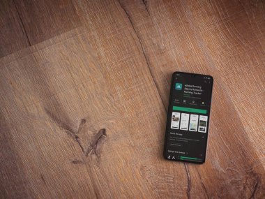 Lod, Israel - 8 Temmuz 2020: Adidas Running app playshop sayfası ahşap arka planda siyah bir cep telefonunun ekranında. Üst görünüm düzlüğü kopyalama alanı ile yatıyordu.