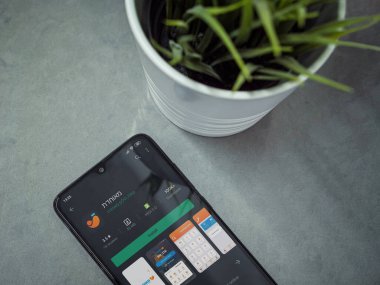 Lod, Israel - 8 Temmuz 2020: Meuhedet Sağlık Hizmetleri uygulama oyun sayfası mermer arka planda siyah cep telefonlu modern minimalist ofis çalışma alanı. Üst görünüm düzlüğü kopyalama alanı ile yatıyordu.