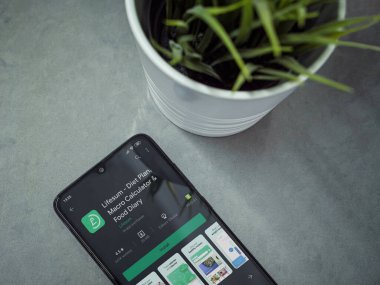 Lod, Israel - 8 Temmuz 2020: Mermer arka planda Lifesum uygulaması oyun mağazası sayfası olan siyah cep telefonlu modern minimalist ofis çalışma alanı. Üst görünüm düzlüğü kopyalama alanı ile yatıyordu.