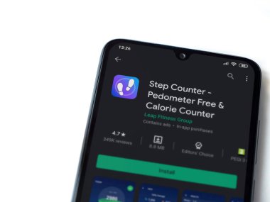 Lod, Israel - 8 Temmuz 2020: Step Counter uygulaması oyun mağazası sayfası beyaz arkaplanda izole edilmiş siyah bir cep telefonu ekranında. Üst görünüm düzlüğü kopyalama alanı ile yatıyordu.