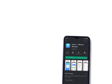 Lod, Israel - 8 Temmuz 2020: Beyaz arka planda izole edilmiş siyah bir cep telefonunun ekranında yedi uygulama oyun mağazası sayfası. Üst görünüm düzlüğü kopyalama alanı ile yatıyordu.
