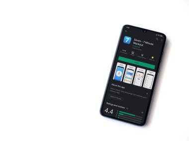 Lod, Israel - 8 Temmuz 2020: Beyaz arka planda izole edilmiş siyah bir cep telefonunun ekranında yedi uygulama oyun mağazası sayfası. Üst görünüm düzlüğü kopyalama alanı ile yatıyordu.