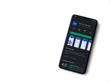 Lod, Israel - 8 Temmuz 2020: Maccbi Sağlık Hizmetleri uygulama oyun mağazası sayfası beyaz arkaplanda izole edilmiş siyah bir cep telefonu ekranında. Üst görünüm düzlüğü kopyalama alanı ile yatıyordu.