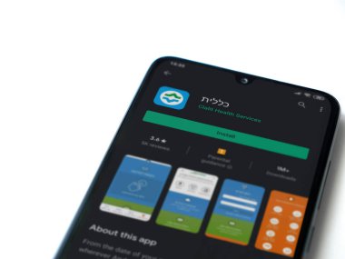 Lod, Israel - 8 Temmuz 2020: Clalit Sağlık Hizmetleri uygulama oyun mağazası sayfası beyaz arkaplanda izole edilmiş siyah bir cep telefonu ekranında. Üst görünüm düzlüğü kopyalama alanı ile yatıyordu.