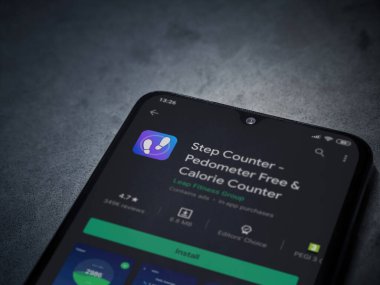 Lod, Israel - 8 Temmuz 2020: Step Counter uygulaması oyun mağazası sayfası koyu mermer taştan arka planda siyah bir cep telefonu ekranında. Üst görünüm düzlüğü kopyalama alanı ile yatıyordu.