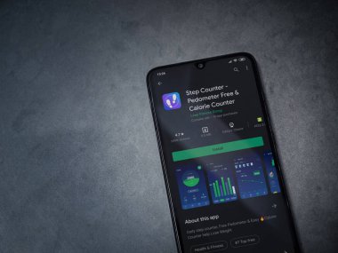 Lod, Israel - 8 Temmuz 2020: Step Counter uygulaması oyun mağazası sayfası koyu mermer taştan arka planda siyah bir cep telefonu ekranında. Üst görünüm düzlüğü kopyalama alanı ile yatıyordu.