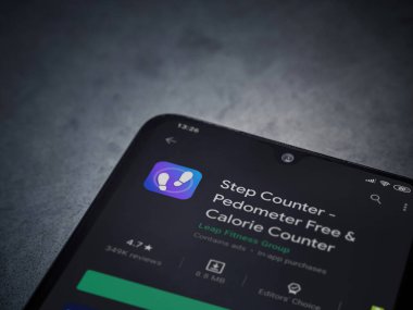 Lod, Israel - 8 Temmuz 2020: Step Counter uygulaması oyun mağazası sayfası koyu mermer taştan arka planda siyah bir cep telefonu ekranında. Üst görünüm düzlüğü kopyalama alanı ile yatıyordu.