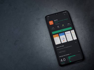 Lod, Israel - 8 Temmuz 2020: Mi Fit uygulaması oyun mağazası sayfası koyu mermer taştan arka planda siyah bir cep telefonu ekranında. Üst görünüm düzlüğü kopyalama alanı ile yatıyordu.