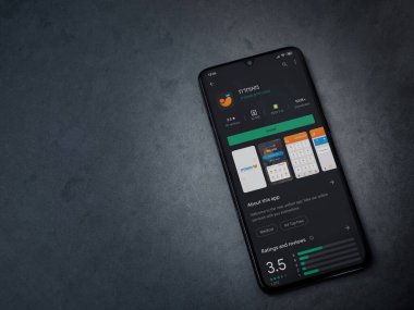 Lod, Israel - 8 Temmuz 2020: Meuhedet Sağlık Hizmetleri uygulama oyun mağazası sayfası koyu mermer taşlı arka planda siyah bir cep telefonu sergilenmektedir. Üst görünüm düzlüğü kopyalama alanı ile yatıyordu.