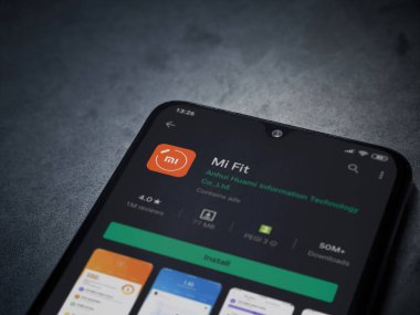 Lod, Israel - 8 Temmuz 2020: Mi Fit uygulaması oyun mağazası sayfası koyu mermer taştan arka planda siyah bir cep telefonu ekranında. Üst görünüm düzlüğü kopyalama alanı ile yatıyordu.