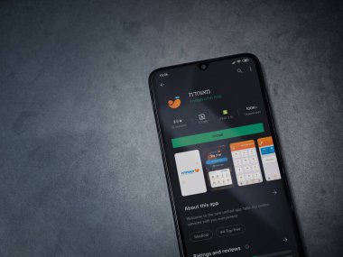 Lod, Israel - 8 Temmuz 2020: Meuhedet Sağlık Hizmetleri uygulama oyun mağazası sayfası koyu mermer taşlı arka planda siyah bir cep telefonu sergilenmektedir. Üst görünüm düzlüğü kopyalama alanı ile yatıyordu.