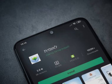 Lod, Israel - 8 Temmuz 2020: Leumit Health Services uygulaması oyun mağazası sayfası koyu mermer taşlı arka planda siyah bir cep telefonu sergilenmektedir. Üst görünüm düzlüğü kopyalama alanı ile yatıyordu.