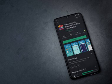 Lod, Israel - 8 Temmuz 2020: Koyu mermer taştan arka planda siyah bir cep telefonunun sergilendiği harika bir uygulama oyun mağazası sayfası. Üst görünüm düzlüğü kopyalama alanı ile yatıyordu.