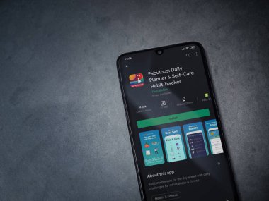 Lod, Israel - 8 Temmuz 2020: Koyu mermer taştan arka planda siyah bir cep telefonunun sergilendiği harika bir uygulama oyun mağazası sayfası. Üst görünüm düzlüğü kopyalama alanı ile yatıyordu.