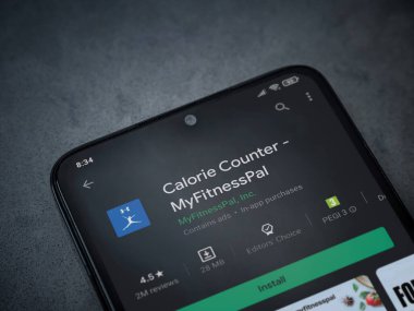 Lod, Israel - 8 Temmuz 2020: MyFitnessPal uygulama oyun mağazası sayfası koyu mermer taşlı arka planda siyah bir cep telefonunun görüntüsü. Üst görünüm düzlüğü kopyalama alanı ile yatıyordu.